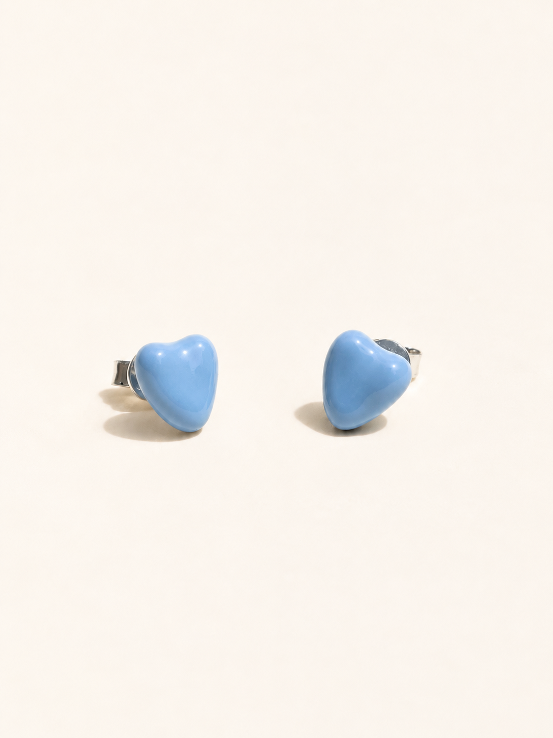 Pair of silver stud earrings on a light gray background